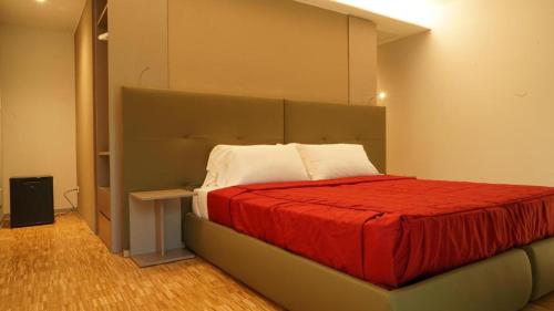 a bedroom with a large bed with a red blanket at Valmarana Morosini Hotel in Altavilla Vicentina