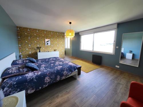 een slaapkamer met een bed en een groot raam bij Cottage chaleureux avec vue sur lac in Changey