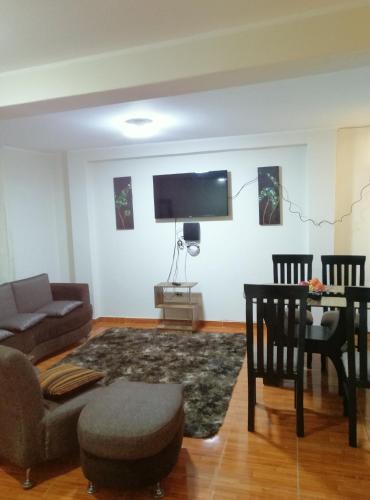 uma sala de estar com um sofá, uma mesa e uma televisão em Departamento D&C I entero acogedor em Huancayo