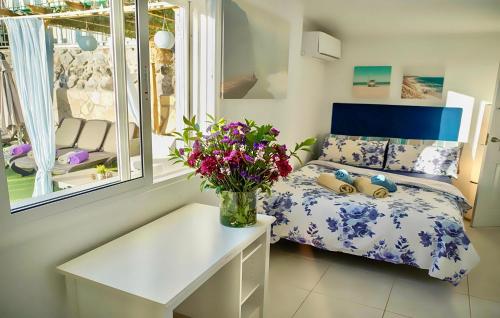 a bedroom with a bed and a vase of flowers at Villa Casa Amada in Callao Salvaje