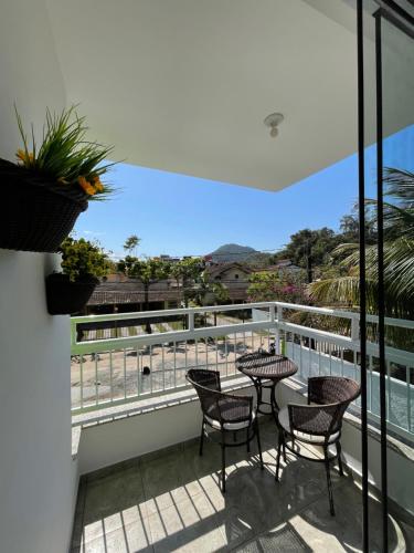 un balcone con tavoli e sedie e vista sull'oceano di Pousada Serrate a Ubatuba