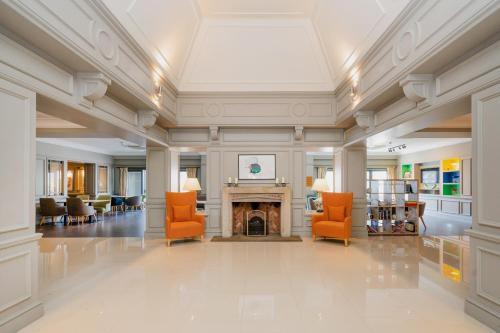 um átrio com cadeiras laranja e uma lareira em Holiday Inn Maidstone-Sevenoaks, an IHG Hotel em Maidstone