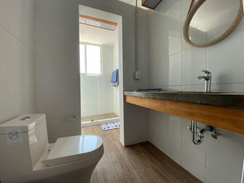 a bathroom with a toilet and a sink and a mirror at TORRE MAR Frente al Malecón in Mazatlán