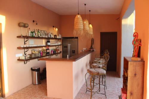 una cocina con una barra con nevera y sillas en Room in Villa - Beautiful Accommodation At The Heart Of Andalusia, en Puente Genil