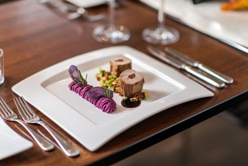 a white plate with some food on a table at Hotel Thorenberg in Luzern