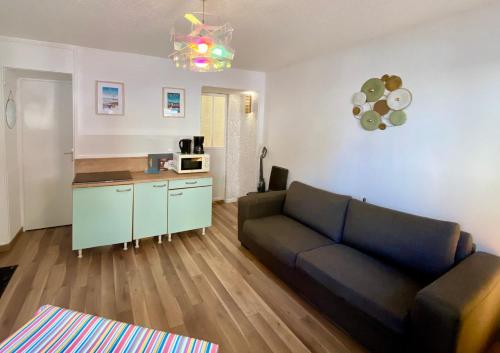 un salon avec un canapé et une cuisine dans l'établissement Petite Sygogne - Front de mer & vue château - Cosy, à Dieppe