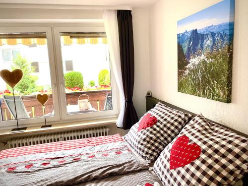 a bedroom with a bed with pillows and a window at Allgäu-Ferienwohnung Jung in Fischen
