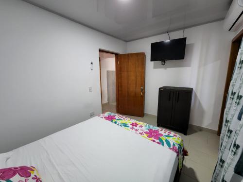 a bedroom with a bed and a tv on the wall at Posada Old Town Bay in Providencia