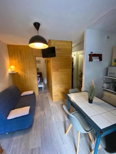 un soggiorno con divano blu e tavolo di T2 bis au pied des montagnes a Saint-Mamet