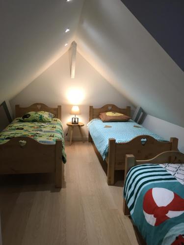 two beds in a room with a attic at Gîte La Grange in Méaudre