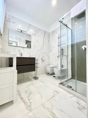 a white bathroom with a sink and a shower and a piano at IL VIAGGIATORE RELAIS SUL MARE in Gaeta