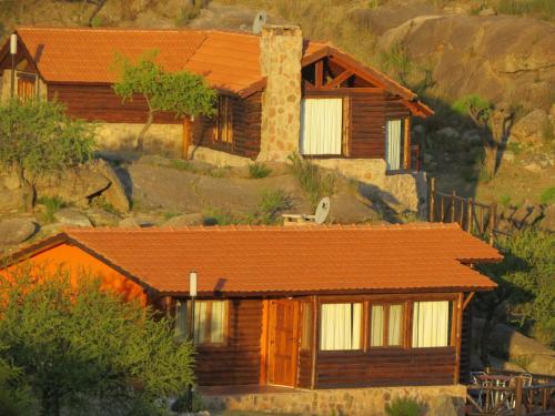 a house with an orange roof on a mountain at Los Ancares Resort in Mina Clavero