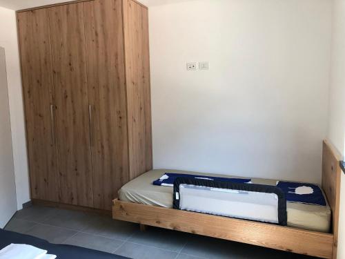 Schlafzimmer mit einem Bett und einem Holzschrank in der Unterkunft Emma‘s Riva-Dream deluxe in Riva del Garda