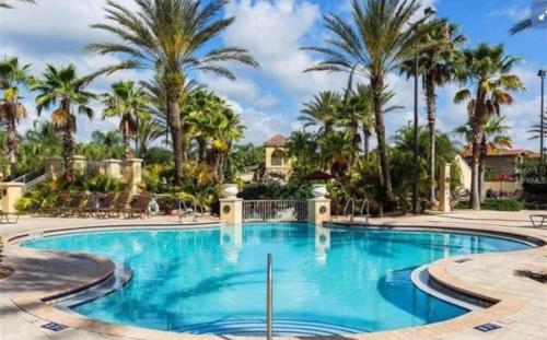 una piscina en un complejo con palmeras en Serene family friendly townhouse in the wonderful Regal Palms, en Davenport