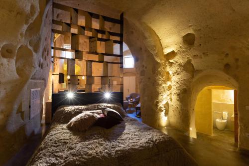 a bedroom with a bed in a stone wall at Grotta Barisano in Matera