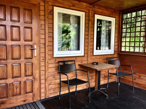 Habitación de madera con mesa y 2 sillas en AB Domki całoroczne nad jeziorem, en Stęszew