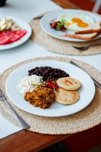 a plate of food on a table with eggs and beans at Hotel California Playa El Yaque in El Yaque