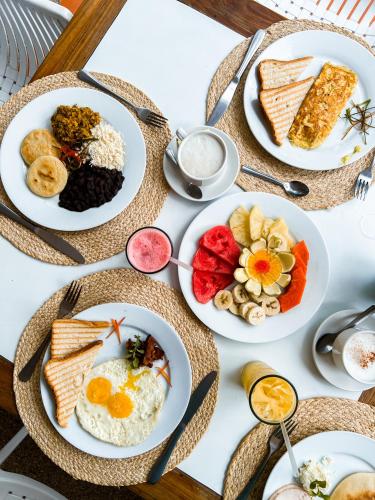 a table with plates of breakfast food on it at Hotel California Playa El Yaque in El Yaque