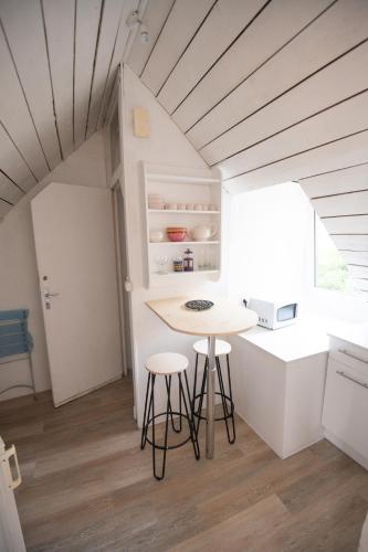 - une petite cuisine avec une table et des tabourets dans l'établissement Les Chambres de Lourmel, à Pontivy