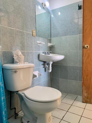 a bathroom with a toilet and a sink at Hotel Casa Juanita in Puerto Escondido