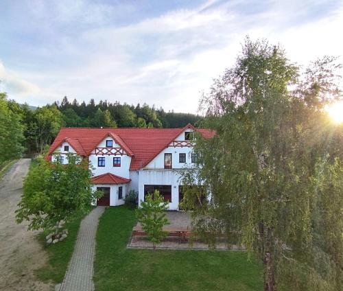 a large white house with a red roof at Koralowa Ścieżka in Jelenia Góra-Jagniątków