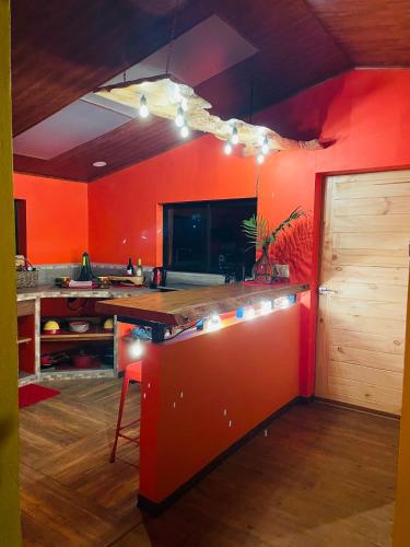a kitchen with red walls and a red counter top at El Sol Monteverde in Monteverde Costa Rica