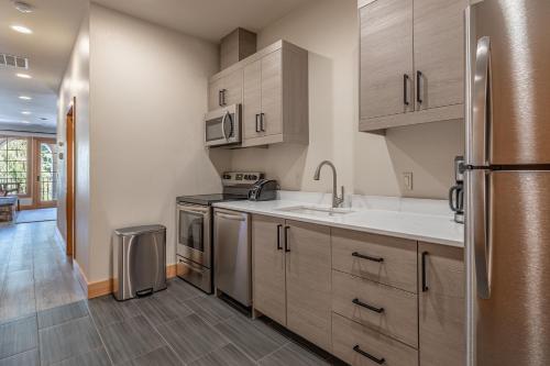 a kitchen with wooden cabinets and a stainless steel refrigerator at Alpen Dorf Pension in Leavenworth