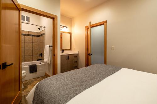 a bedroom with a bed and a bathroom with a tub at Alpen Dorf Pension in Leavenworth