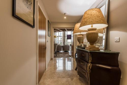 a hallway with a dresser with a lamp on it at Executive Corporate Penthouse in Woking