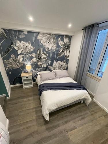 a bedroom with a bed with a floral wallpaper at Les Apparts de la Bastide 35A in Villeneuve-sur-Lot