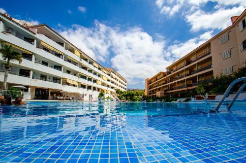 a swimming pool in front of a building at SUMMERLAND SUNSET in Los Cristianos