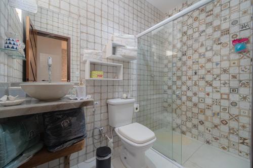 a bathroom with a toilet and a sink and a shower at Pousada Recanto da Família in Natal