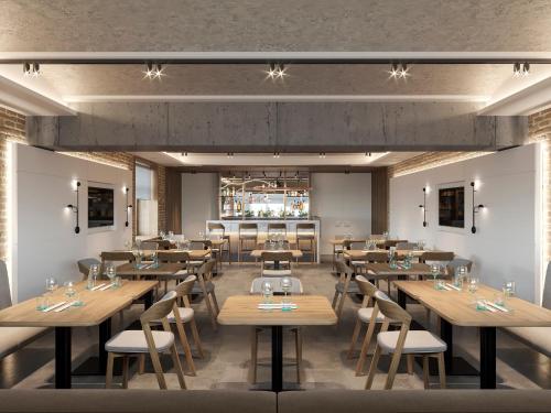 un restaurant avec des tables et des chaises en bois ainsi qu'un bar dans l'établissement Bontiak Hotel, à Kiev