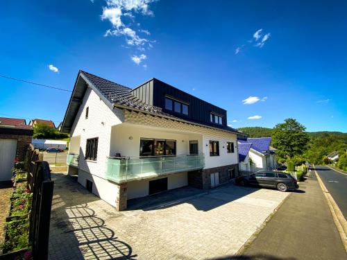 uma casa com um telhado preto numa rua em NRing Villa am Nürburgring em Adenau