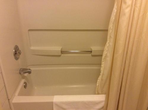 a bathroom with a tub and a shower curtain at Travelodge by Wyndham Victoriaville in Victoriaville