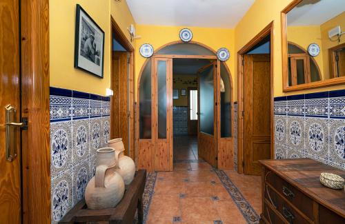 a hallway with wooden doors and vases on the walls at Casa Sagrario in Santa María de los Llanos