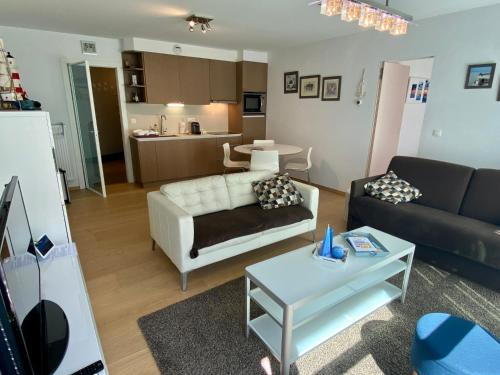 - un salon avec un canapé et une table dans l'établissement Even naar zee Nieuwpoort Appartement Waterkant, à Nieuport