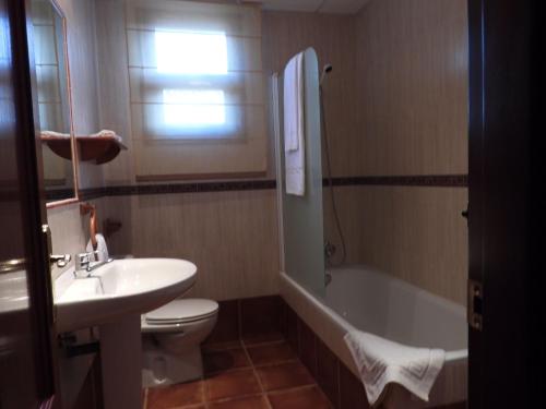 a bathroom with a sink and a toilet and a bath tub at Hotel Rural Carlos Astorga in Archidona