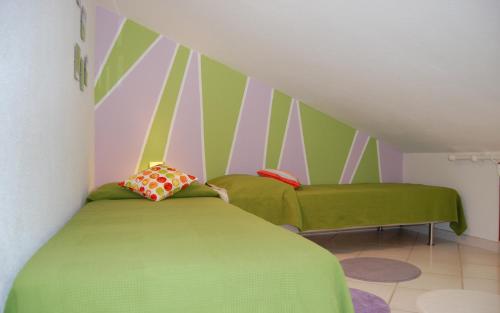 a bedroom with a green bed and a striped wall at Casa Bellavista in Monte Nai