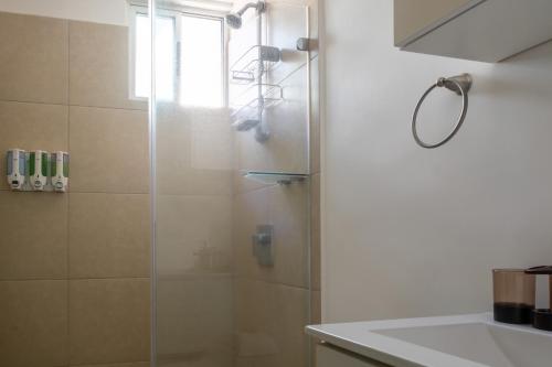 W łazience znajduje się prysznic ze szklanymi drzwiami. w obiekcie Lujoso condominio con lavadora y secadora, S. José w San José