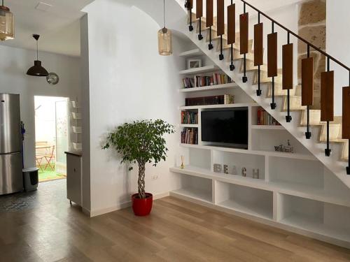 een woonkamer met een trap met een tv en een potplant bij Castle view in Alicante