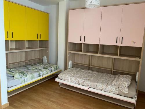a bedroom with two bunk beds and yellow cabinets at Castle view in Alicante