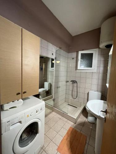 a bathroom with a washing machine and a shower at Ioanna's house in Agios Georgios