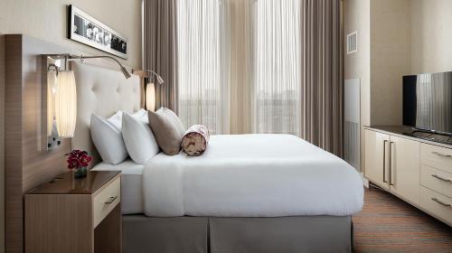ein Hotelzimmer mit einem weißen Bett und einem TV in der Unterkunft Hotel AKA Back Bay in Boston