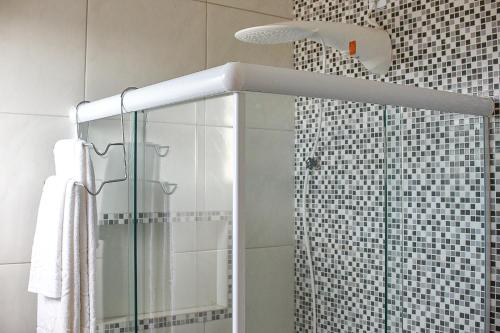 a shower with a glass door in a bathroom at Casa DasCli in Camocim