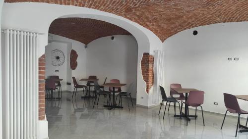 um quarto com mesas e cadeiras e uma parede de tijolos em Novara em Novara