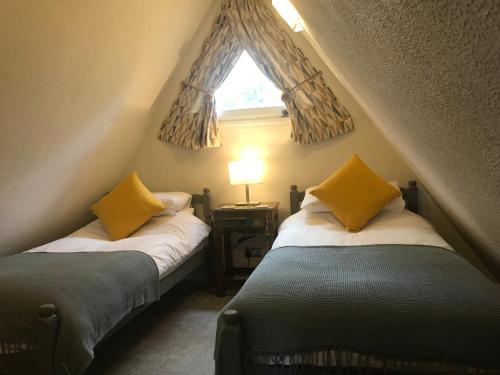 two beds in a small room with a window at Foxes Sea Side Retreat Deluxe Chalet is a lovely holiday home tucked away on the Kent Coast in Kingsdown