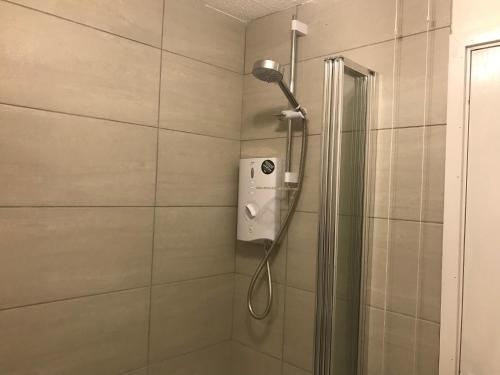 a shower with a shower head in a bathroom at Foxes Sea Side Retreat Deluxe Chalet is a lovely holiday home tucked away on the Kent Coast in Kingsdown