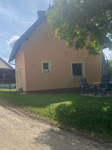 a house with chairs and a table in the yard at Ferienhaus Gunzenberg in Gunzenberg
