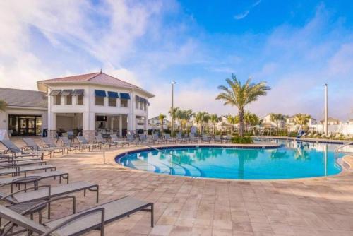 ein Resortpool mit Stühlen und ein Gebäude in der Unterkunft Villa, private pool, water park, Orlando parks in Kissimmee